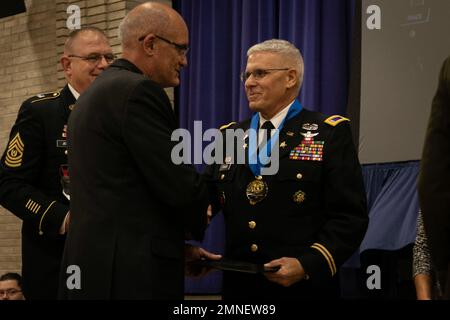 Presidente del Consiglio di Memorializzazione, Gen. Maggiore (Ret.) David Elicerio si congratula con il Chief Warrant Officer 5 (Ret.) Peter T. Panos durante la cerimonia di investitura della Corte d'onore al Centro ricreativo John W. Vessey vicino a Camp Ripley, 2 ottobre 2022, a Little Falls, Minnesota. Panos si arruolò nella Guardia Nazionale del Minnesota nel 1994 dopo aver prestato servizio per sei anni nel corpo dei Marine e per 12 anni nelle riserve dell'Esercito. In totale, Panos dedicò oltre 40 anni della sua vita al servizio militare. (Foto della Guardia Nazionale del Minnesota del personale Sgt. Mahsima Alkamooneh) Foto Stock
