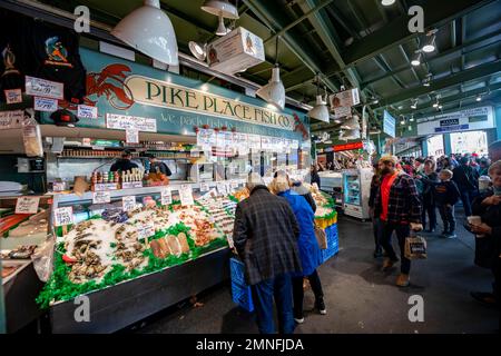 Persone in una sala del mercato, stalle di vendita di pesce fresco, mercato pubblico, mercato agricolo, Pike Place Market, Seattle, Washington, Stati Uniti Foto Stock