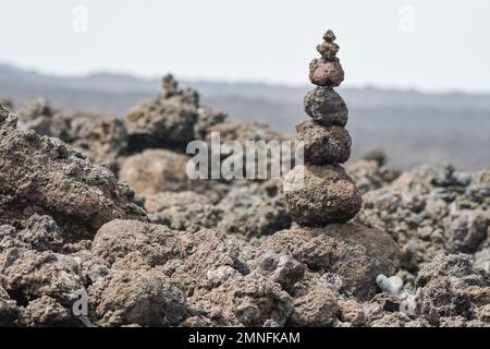 Pietre vulcaniche impilate accanto al sentiero costiero di Lanzarote Foto Stock