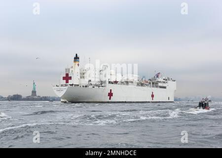 Gli asset della Guardia Costiera, insieme al Dipartimento di polizia di New York e al Dipartimento dei vigili del fuoco di New York, forniscono una scorta di sicurezza per l'arrivo dell'USNS Comfort nel porto di New York, il 30 marzo 2020. La Guardia Costiera Cutter Shrike, la Guardia Costiera Cutter Sitkinak, il Maritime Safety and Security Team di New York, e gli equipaggi della Guardia Costiera della Stazione di New York e della Guardia Costiera della Stazione aerea di Cape Cod hanno condotto la scorta mentre il Comfort è arrivato a New York per assistere nella risposta del COVID-19. Foto Stock