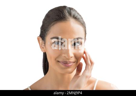 Ritratto di giovane donna sorridente che applica la crema per il viso Foto Stock