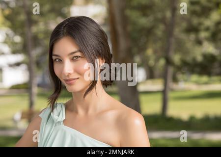 Ritratto di bella donna che guarda la macchina fotografica nel parco Foto Stock