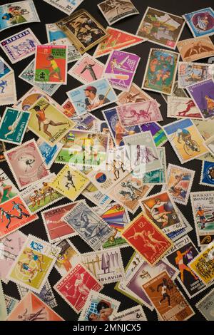 Vecchi francobolli assortiti provenienti da vari paesi che commemorano vari sport olimpici. Foto Stock