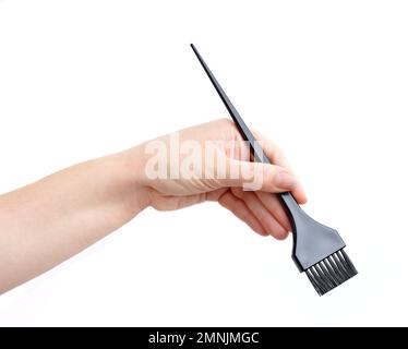 mano che raccoglie una spazzola per tingere i capelli Foto Stock