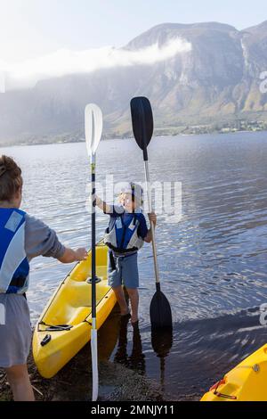 Sudafrica, Stanford, ragazzo e ragazza adolescente (10-11, 16-17) che si preparano per il kayak Foto Stock