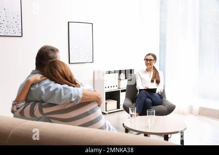 Psicoterapeuta e felice coppia che si riunisce in ufficio. Consulenza familiare Foto Stock