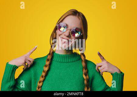 Foto di una giovane donna adorabile e brillante vestita casual occhiali che sorridono alla macchina fotografica isolato su sfondo di colore giallo Foto Stock