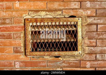 Grata di ventilazione arrugginita in Red Brick Wall Foto Stock