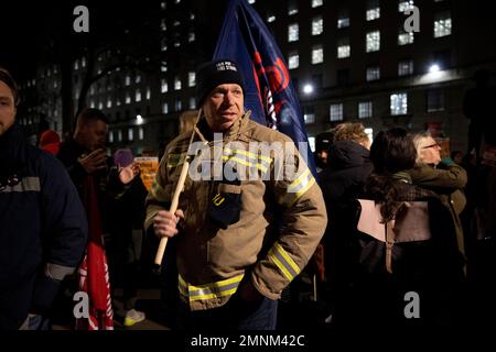 Londra, Regno Unito. 30th Jan, 2023. Un protester dall'Unione delle Brigate di fuoco (FBU) è visto con una bandiera dell'Unione durante il abbastanza è abbastanza protesta. Al di fuori di Downing Street si è svolta una protesta invocata da vari sindacati britannici in risposta al dibattito in corso sulla legge anti-sciopero e sulla legge sull'ordine pubblico nella Camera del comune del Parlamento britannico. Questi disegni di legge minacciano i diritti di protesta e sciopero dei civili. Credit: SOPA Images Limited/Alamy Live News Foto Stock