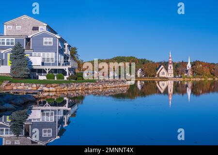 Riflessioni di chiese con colore fogliame autunno a Mahone Bay, Nuova Scozia, Canada. Foto Stock