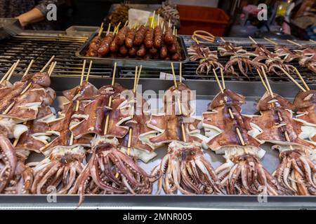 Spiedini calamari in vendita presso la stalla stradale a Taipei, Taiwan. Foto Stock