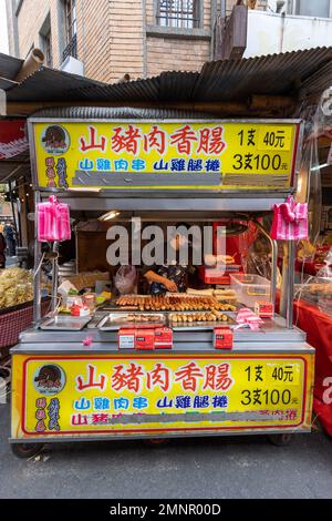 Stand che vende salsicce di cinghiale al mercato di Capodanno di Dihua a Taipei, Taiwan. Foto Stock