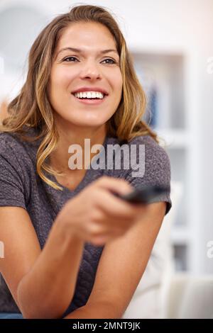 Guardare uno di quei film di sentirsi bene. una giovane donna che guarda la televisione a casa. Foto Stock