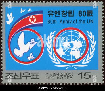Francobollo nordcoreano del 2005 per commemorare il 60° anniversario delle Nazioni Unite, con il logo delle Nazioni Unite e una colomba di pace. Foto Stock