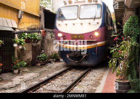 Hanoi, Vietnam, gennaio 2023. il treno che passa tra le case nel centro storico della città Foto Stock