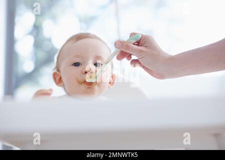 Godendo di ogni bocca. Vista ad angolo basso di un bambino che viene nutrito da sua madre. Foto Stock