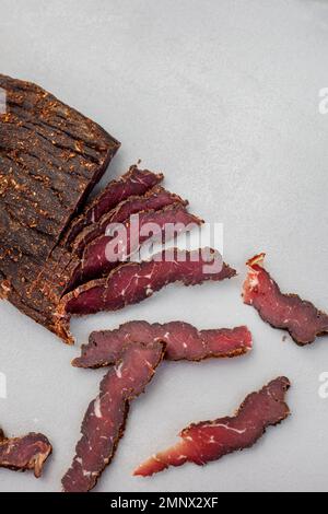 Biltong sudafricano tagliato di recente su sfondo chiaro con messa a fuoco selettiva e spazio copia Foto Stock