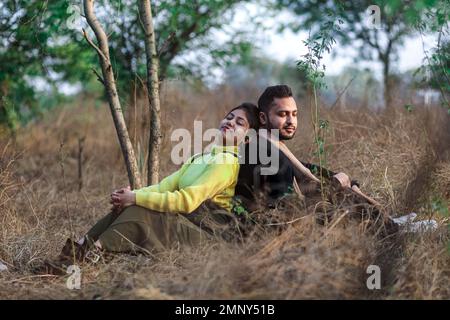 Foto pre-matrimonio di una coppia indiana nel sentiero natura a Delhi, India. Coppia romantica Shoot. Sposa e sposo nella foresta naturale di con alberi. Foto Stock