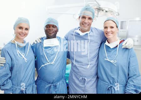 Siamo parte di una famiglia in questo ospedale. Una squadra felice di medici chirurghi e medici che si imbarcano in un teatro operativo - lavoro di squadra. Foto Stock