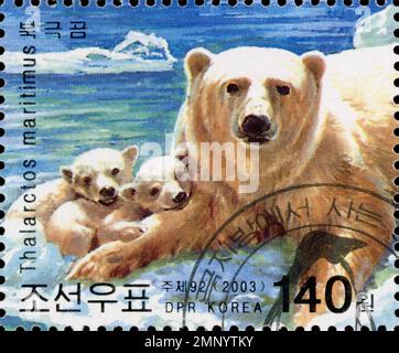 Francobollo nordcoreano del 2003 con una madre orso polare e due cuccioli, con testo coreano e latino. Foto Stock