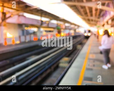 Immagine sfocata della stazione ferroviaria prima del tramonto, skytrain BTS a Bangkok, Thailandia Foto Stock