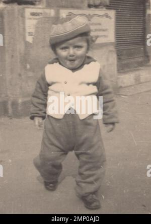 vintage moment / vintage funny moment / vintage fotografia / la potenza del momento / momenti magici / qui si verificano problemi. foto vintage del bambino degli anni '1930s. Un ragazzino sorridente arriva alla macchina fotografica. abiti vintage per bambini/abiti vintage per bambini Foto Stock