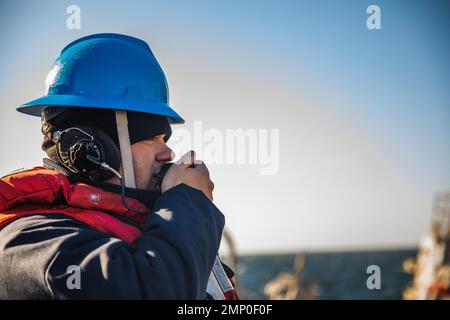 221007-N-GF955-1098 MAR BALTICO (OTT 7, 2022) U.S. Navy Fire Controlman (Aegis) 2nd Classe Stephen Sharp, di Crawfordville, Florida, comunica con il ponte a bordo del cacciatorpediniere missilistico guidato di classe Arleigh Burke USS Paul Ignatius (DDG 117) durante un rifornimento in mare con la nave da carico secco e munizioni di classe Lewis e Clark USNS William McLean (T-AKE 12, 7 ottobre 2022). Paul Ignatius, schierato in futuro a Rota, Spagna, è in un schieramento programmato nell'area delle operazioni delle forze Navali USA in Europa, impiegato dalla U.S. Sesta flotta, per difendere gli interessi degli Stati Uniti, alleati e partner. Foto Stock