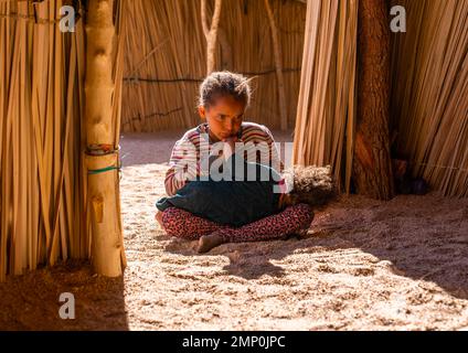 Tuareg ragazza con la sorella piccola in una casa di canna, Nord Africa, Tamanrasset, Algeria Foto Stock