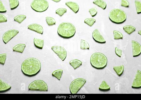 Fette di fresco e succoso lime sul tavolo di marmo, vista dall'alto Foto Stock