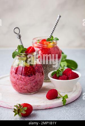 Budini di semi di chia con frutti di bosco e frutta per colazione Foto Stock