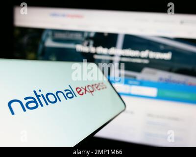 Cellulare con il logo della società britannica National Express Group plc (NX) sullo schermo di fronte al sito web aziendale. Messa a fuoco a sinistra del display del telefono. Foto Stock