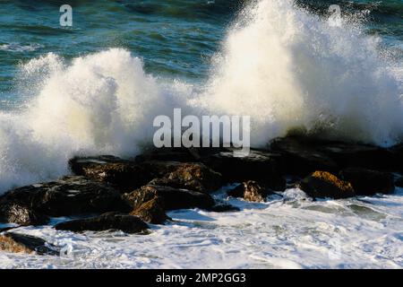 mare ​​waves che si schiantano sulle rocce Foto Stock