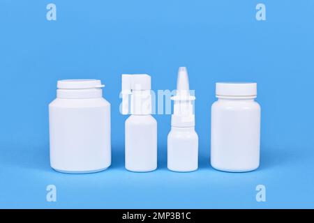 Farmaco per freddo e canna fumaria. Spray nasale, spray alla gola, pillole su sfondo blu Foto Stock