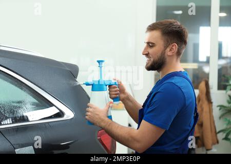 Spruzzare acqua sul finestrino dell'auto prima di colorare Foto Stock