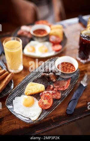 Prima colazione friggere il brunch gastro pub fagiolini inglesi bap pomodoro nero budino patate hash marrone uova strapazzate pancetta gustoso cibo classico pasto Foto Stock