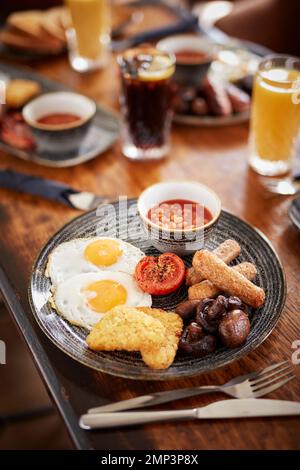 Prima colazione friggere il brunch gastro pub fagiolini inglesi bap pomodoro nero budino patate hash marrone uova strapazzate pancetta gustoso cibo classico pasto Foto Stock