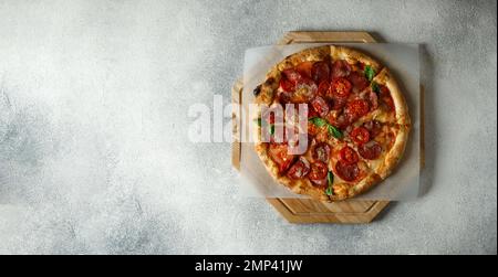 Pizza italiana Margherita con pomodori, basilico e mozzarella. Pizza Margarita su sfondo di pietra grigia, vista dall'alto. Copia spazio per il testo. bann. Web Foto Stock