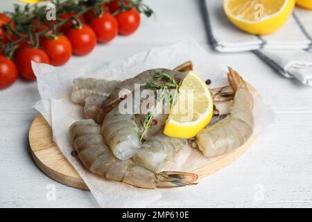 Gamberetti freschi crudi con limone e timo su tavola di legno bianco Foto Stock