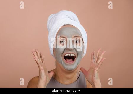 Ritratto di donna anziana eccitata con maschera facciale, auto-cura e concetto di routine della pelle. Foto Stock