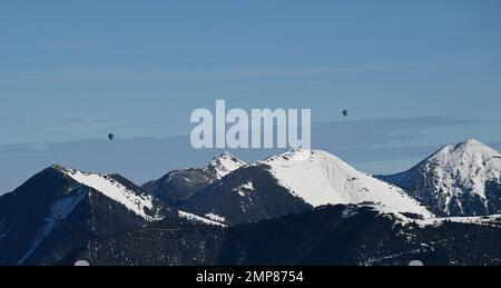 Garmisch Partenkirchen, Germania. 31st Jan, 2023. Due mongolfiere galleggiano sopra le cime innevate dell'Estergebirge, chiamata anche Krottenkopfgebirge. Credit: Angelika Warmuth/dpa/Alamy Live News Foto Stock