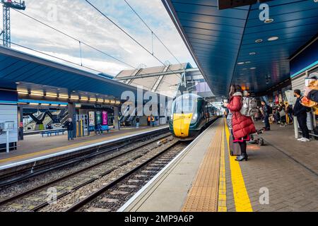 Un treno GWR arriva al binario alla stazione ferroviaria di Reading nel Berkshire, Regno Unito, mentre i passeggeri aspettano di salire a bordo del nuovo arrivo Foto Stock