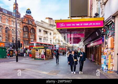 Una bancarella di souvenir fuori dal Dominion Theatre su Tottenham Court Road a Londra, Regno Unito, è bagnata dal sole del mattino di golding in un giorno d'inverno Foto Stock