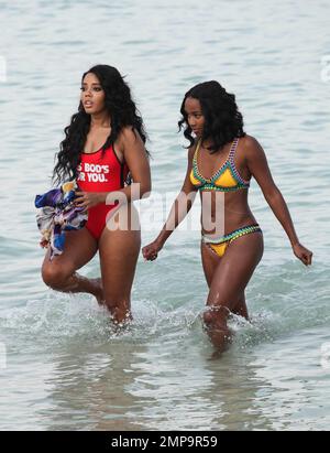 Angela Simmons è visto lavorare a una ripresa video con un equipaggio sulla spiaggia. Poi si vede rinfrescarsi nell’oceano con un amico mentre indossa un costume da bagno rosso con le parole: “Questo ragazzo per te”. Le belle Signore sono state anche viste fare backflip dalla riva del mare. Miami Beach, Florida. Marzo 23, 2015. Foto Stock