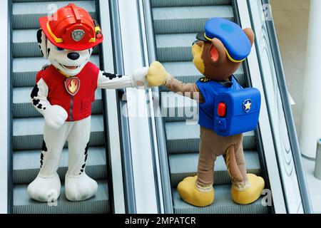 Norimberga, Germania. 31st Jan, 2023. Due artisti vestiti come personaggi comici di PAW Patrol cavalcano una scala mobile durante lo spettacolo di novità Spielwarenmesse. Il 72nd Spielwarenmesse si svolge dal 1 al 5 febbraio 2023. Credit: Daniel Karmann/dpa/Alamy Live News Foto Stock