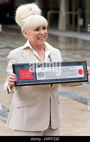 L'attrice Barbara Windsor sfida la pioggia per mostrare il suo premio dopo aver ottenuto la "libertà della città di Londra". Guildhall, Londra, Regno Unito. 8/4/10. . Foto Stock