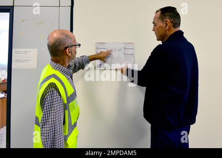 A sinistra, Marco Ruberti, Safety Specialist, assegnato al Battaglione di supporto dell'Esercito – Africa, 405th Brigata di supporto dell'Esercito – Europa e Africa, mostra Luciano Lazzeri, ispettore antincendio, assegnato ai servizi di emergenza dei Vigili del fuoco, Camp Darby USAG Italia, la mappa dell'edificio e il piano di evacuazione in caso di incendio, durante la settimana di prevenzione degli incendi. Camp Darby, DEPOT, Italia, 13 ottobre 2022. Foto Stock