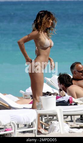 La bambina bikini Belen Rodriguez sfoca la sua incredibile figura mentre si rilassa con un gruppo di amici femminili sull'oceano a South Beach. Durante il giorno, la modella argentina girò l'attrice scambiò un bikini rosa per un bikini dalle tonalità della pelle che a malapena conteneva le sue curve. Belen che ha avuto una serie di famosi boyfriends, tra cui calciatori, sta attualmente datando la personalità televisiva italiana Fabrizio Corona. Miami, Florida. 3/6/10. Foto Stock