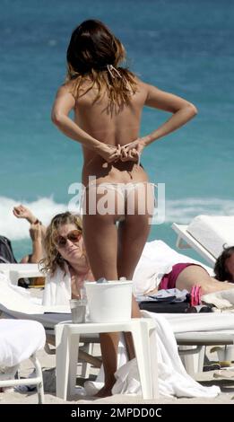 La bambina bikini Belen Rodriguez sfoca la sua incredibile figura mentre si rilassa con un gruppo di amici femminili sull'oceano a South Beach. Durante il giorno, la modella argentina girò l'attrice scambiò un bikini rosa per un bikini dalle tonalità della pelle che a malapena conteneva le sue curve. Belen che ha avuto una serie di famosi boyfriends, tra cui calciatori, sta attualmente datando la personalità televisiva italiana Fabrizio Corona. Miami, Florida. 3/6/10. Foto Stock