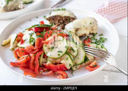 Insalata di zucchine con pomodori e peperoni marinati con olio d'oliva, miele, aceto ed erbe aromatiche Foto Stock