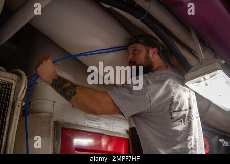 221013-N-YT061-1010 NORFOLK, Virginia (ott 13, 2022) Adam Keller, di Norfolk, Virginia, un appaltatore per la gestione dell'aviazione Analytical Consultants, monta cavi a bordo della portaerei di classe Nimitz USS Harry S. Truman (CVN 75), 13 ottobre 2022. Truman è la nave ammiraglia del gruppo di carrier Strike di Harry S. Truman ed è attualmente nel porto a bordo della base navale di Norfolk. Foto Stock